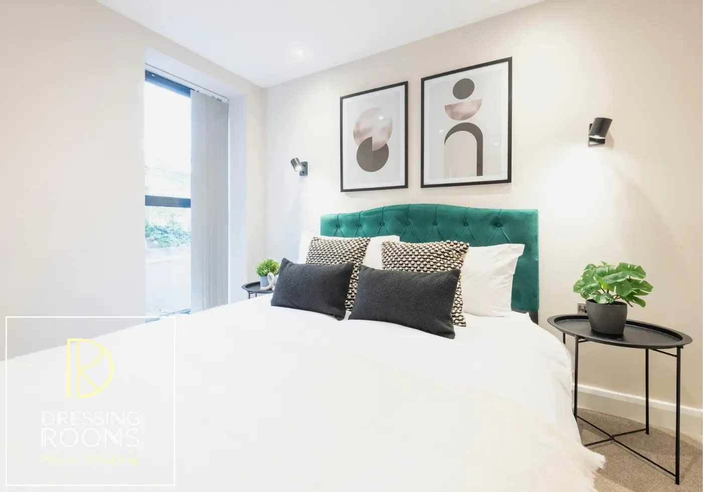 Guest bedroom with monochrome artwork and bedside plant