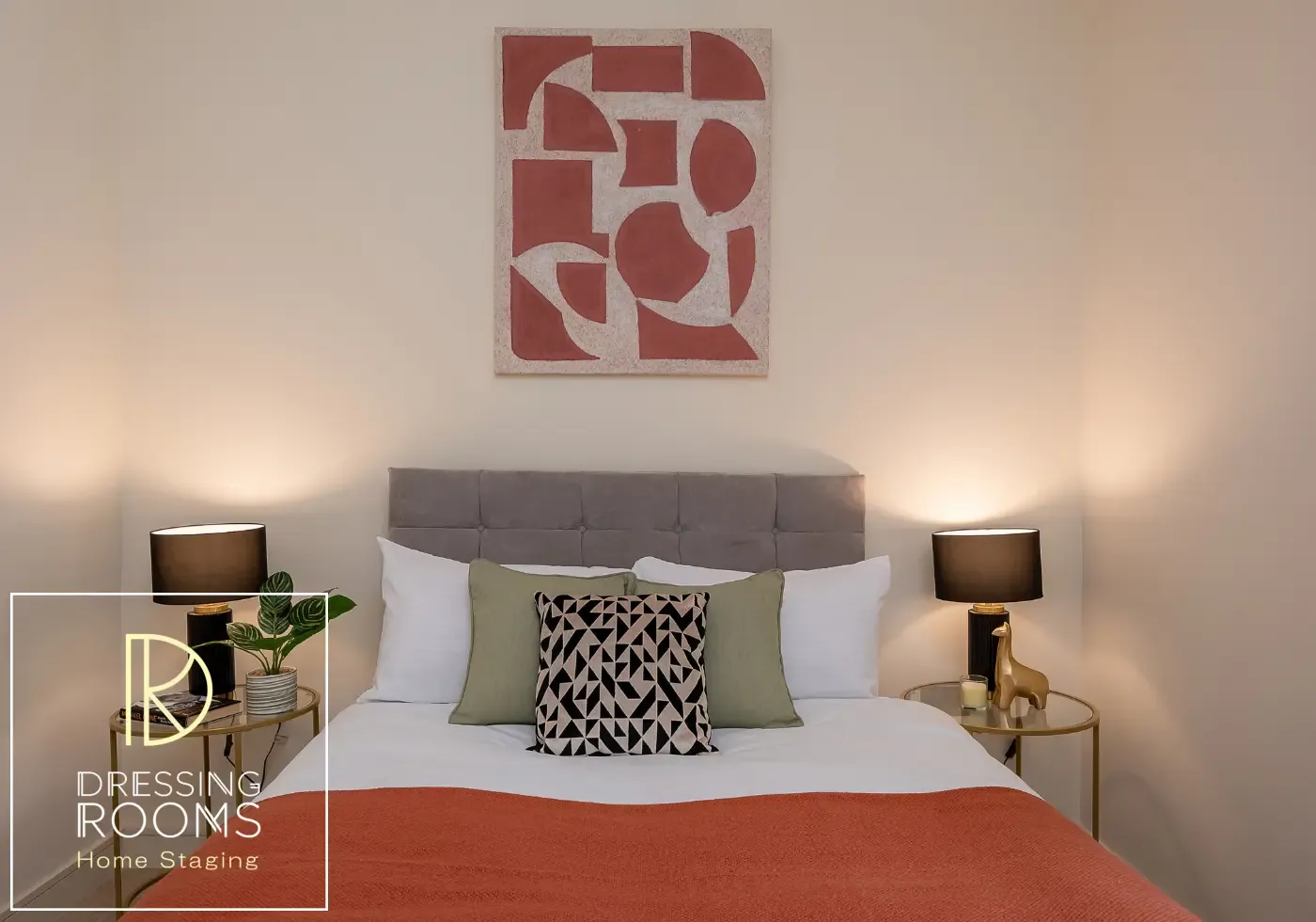 Grey upholstered bed styled with patterned cushions