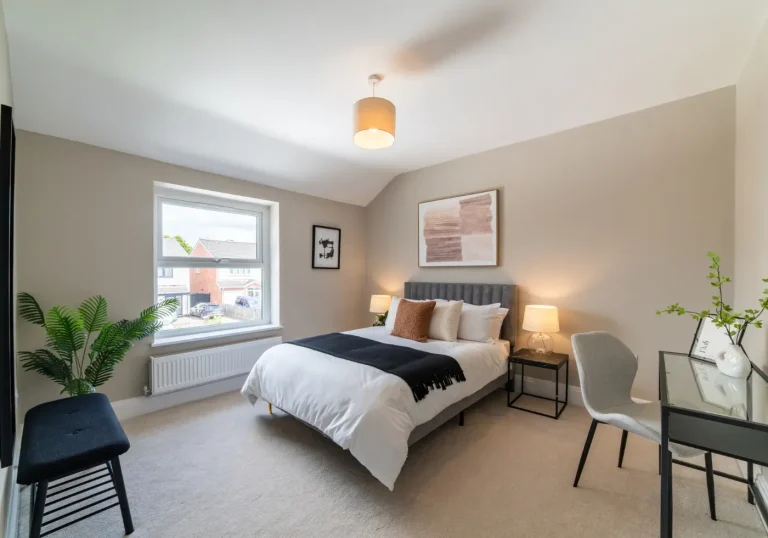 After home staging bedroom with black desk and cream bed