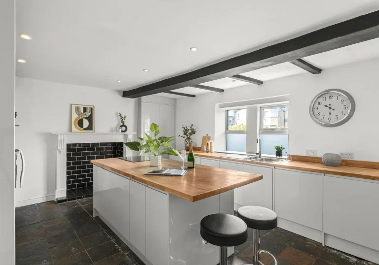 After staging kitchen with bar stools and white walls